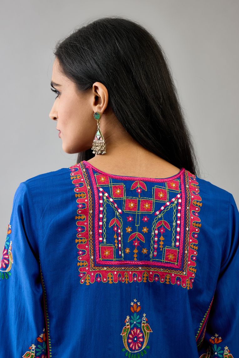 Blue silk straight kurta set with yoke and side panels. It has allover patchwork and silk thread embroidery, highlighted with mirror, sequins, tassels and braids.