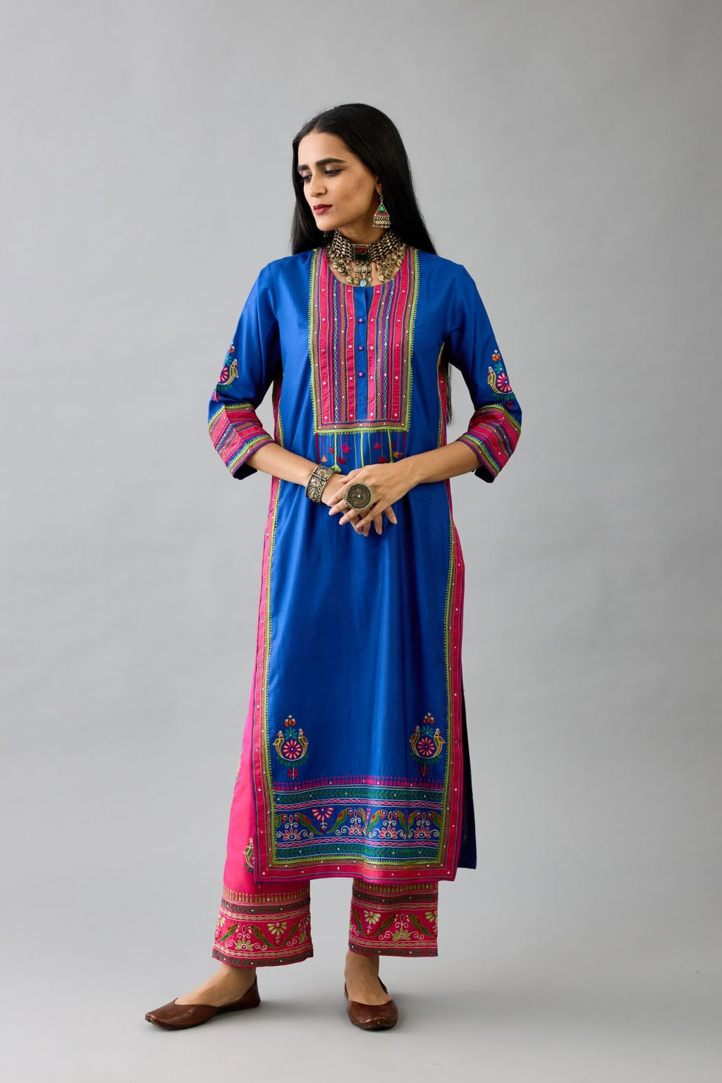 Blue silk straight kurta with yoke with patchwork and silk thread embroidery highlighted with mirror, sequins, tassels and braids.
