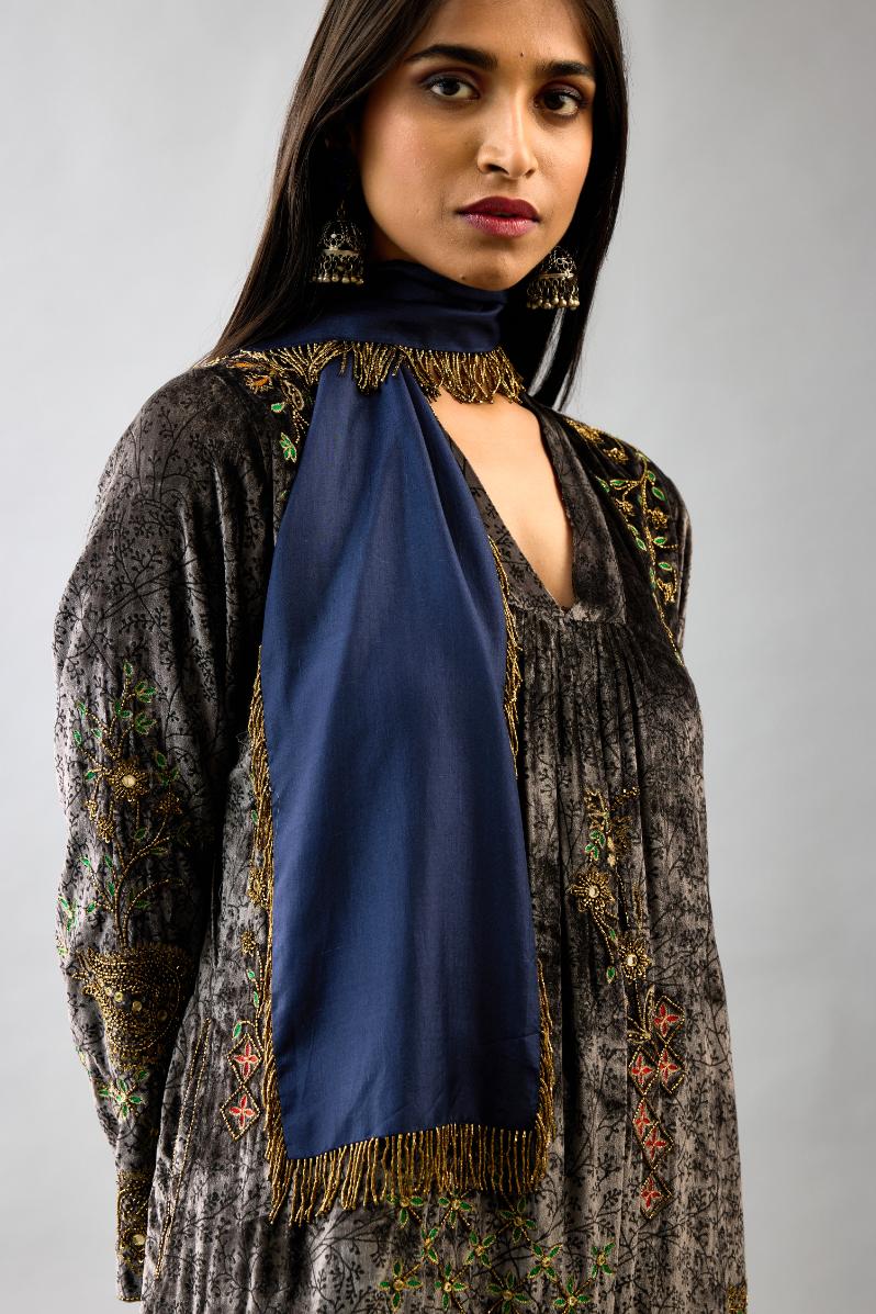 Grey silk velvet hand block printed easy fit dress with, highlighted with beads, sequins and zari work, paired with blue light silk narrow stole with bugle beads fringes.