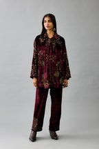 Maroon silk velvet shirt with all-over hand block print, highlighted with sequins, beads and zari work, paired with maroon silk velvet hand block printed straight pants with embroidered boota at sides, highlighted with sequins, beads and zari work.