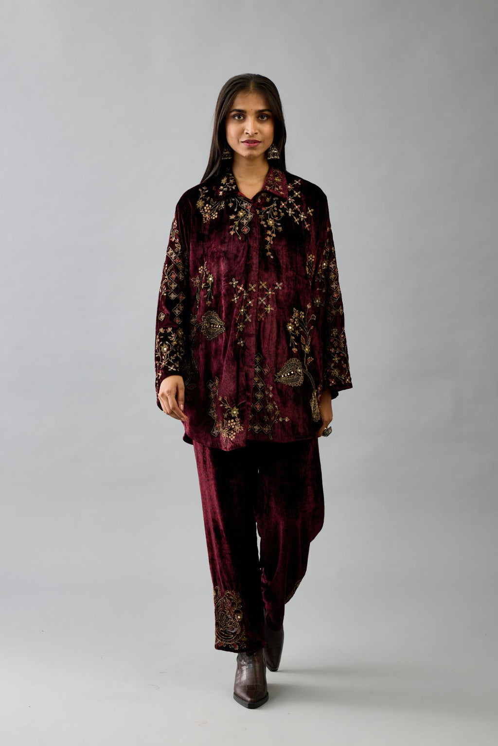 Maroon silk velvet shirt with all-over hand block print, highlighted with sequins, beads and zari work, paired with maroon silk velvet hand block printed straight pants with embroidered boota at sides, highlighted with sequins, beads and zari work.