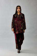 Maroon silk velvet shirt with all-over hand block print, highlighted with sequins, beads and zari work, paired with maroon silk velvet hand block printed straight pants with embroidered boota at sides, highlighted with sequins, beads and zari work.