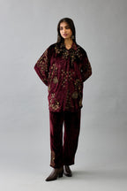 Maroon silk velvet shirt with all-over hand block print, highlighted with sequins, beads and zari work, paired with maroon silk velvet hand block printed straight pants with embroidered boota at sides, highlighted with sequins, beads and zari work.