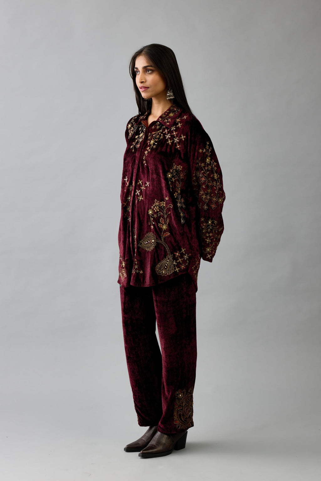 Maroon silk velvet shirt with all-over hand block print, highlighted with sequins, beads and zari work, paired with maroon silk velvet hand block printed straight pants with embroidered boota at sides, highlighted with sequins, beads and zari work.