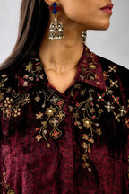 Maroon silk velvet shirt with all-over hand block print, highlighted with sequins, beads and zari work, paired with maroon silk velvet hand block printed straight pants with embroidered boota at sides, highlighted with sequins, beads and zari work.