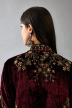Maroon silk velvet shirt with all-over hand block print, highlighted with sequins, beads and zari work, paired with maroon silk velvet hand block printed straight pants with embroidered boota at sides, highlighted with sequins, beads and zari work.