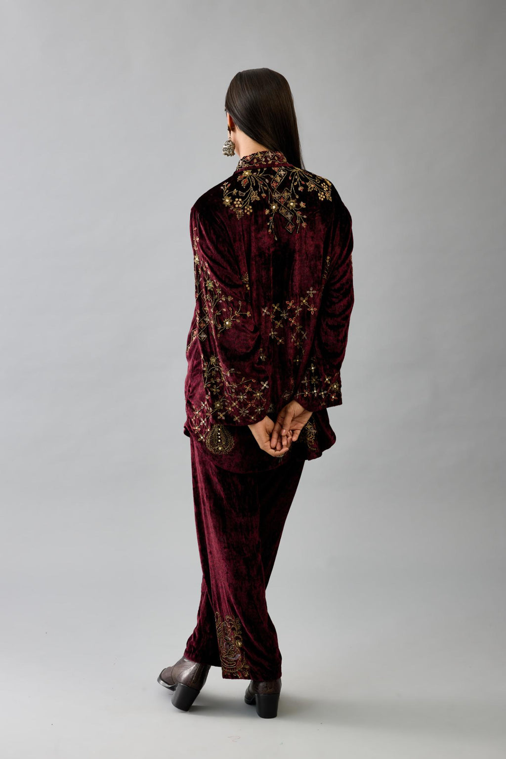 Maroon silk velvet shirt with all-over hand block print, highlighted with sequins, beads and zari work, paired with maroon silk velvet hand block printed straight pants with embroidered boota at sides, highlighted with sequins, beads and zari work.