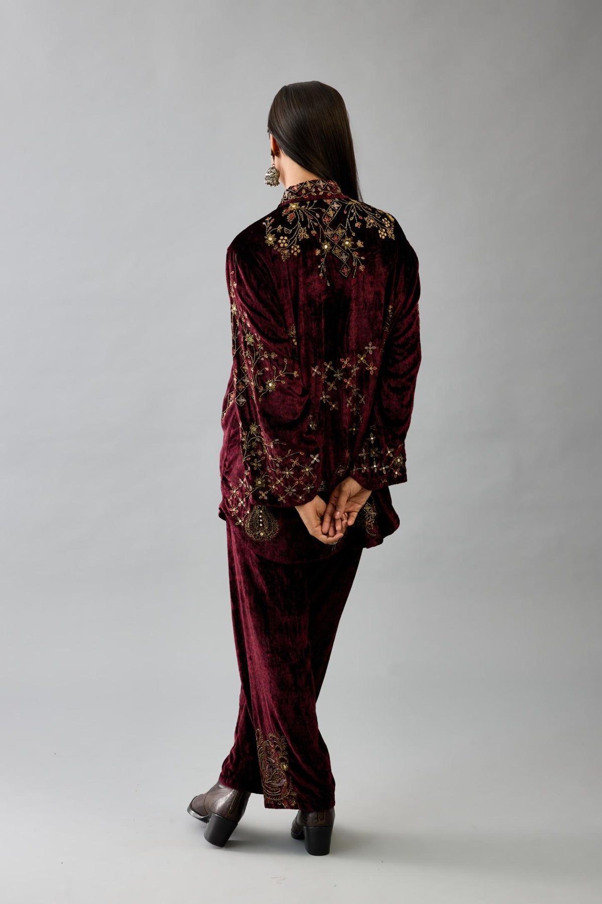 Maroon silk velvet shirt with all-over hand block print, highlighted with sequins, beads and zari work, paired with maroon silk velvet hand block printed straight pants with embroidered boota at sides, highlighted with sequins, beads and zari work.
