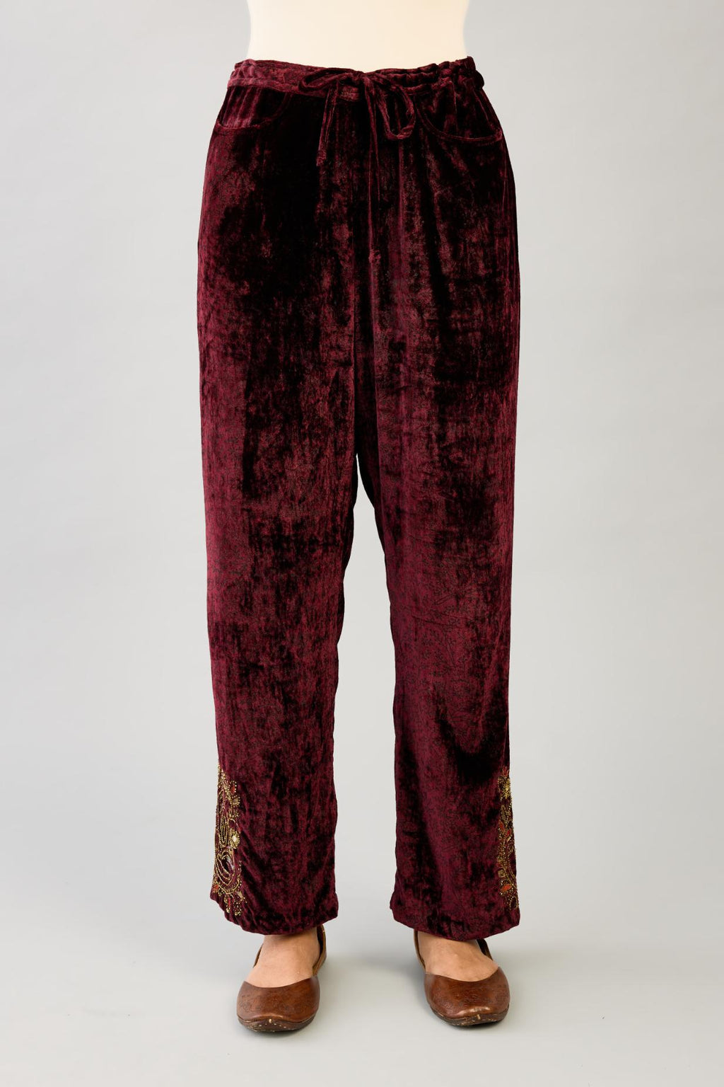 Maroon silk velvet hand block printed straight pants with embroidered boota at sides, highlighted with sequins, beads and zari work.