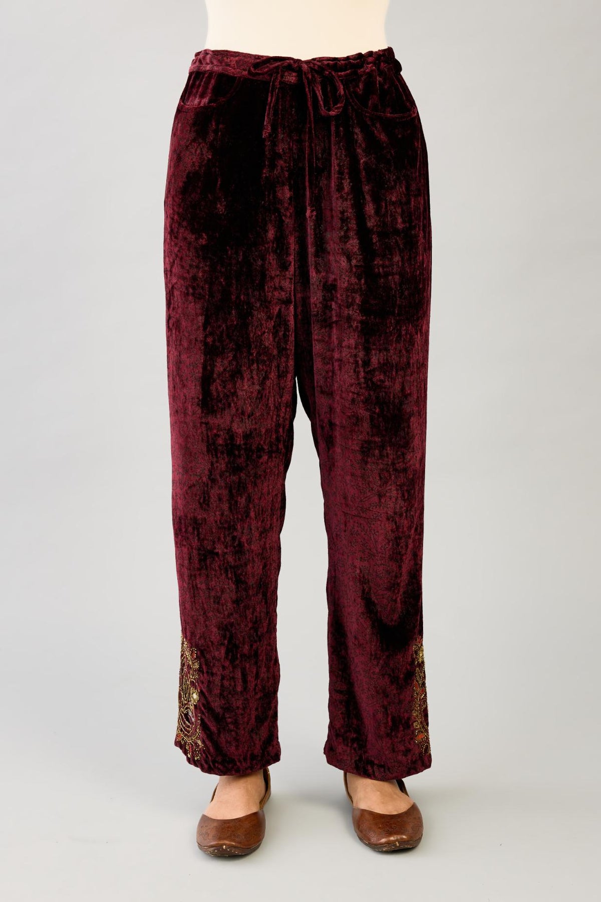 Maroon silk velvet hand block printed straight pants with embroidered boota at sides, highlighted with sequins, beads and zari work.