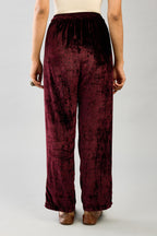Maroon silk velvet hand block printed straight pants with embroidered boota at sides, highlighted with sequins, beads and zari work.