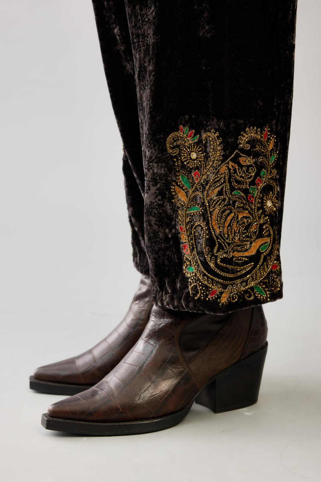 Grey silk velvet hand block printed straight pants with embroidered boota at sides, highlighted with sequins, beads and zari work.