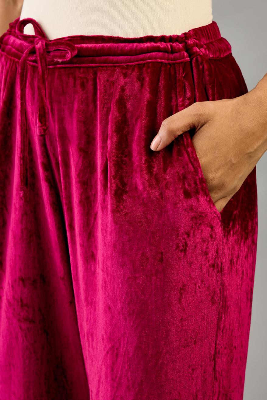 Fuchsia silk velvet straight pants with dori and contrast silk thread embroidery, detailed with gold sequins work.
