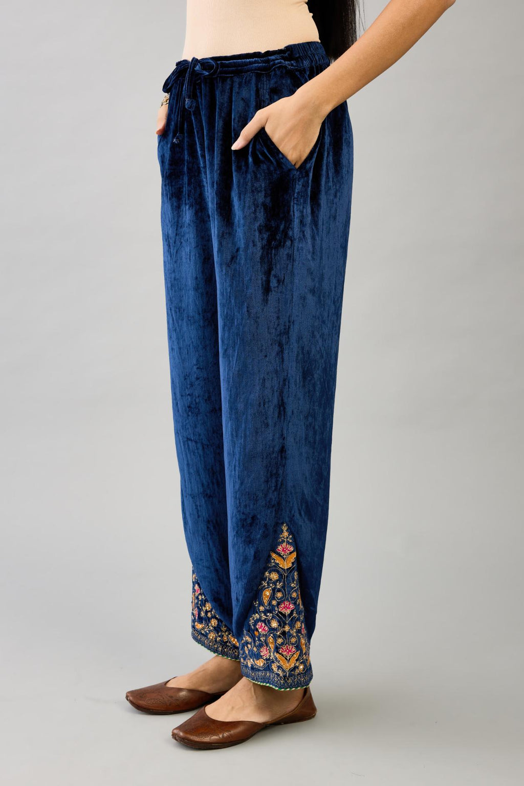 Blue silk velvet straight pants with dori and contrast silk thread embroidery, detailed with gold sequins work.