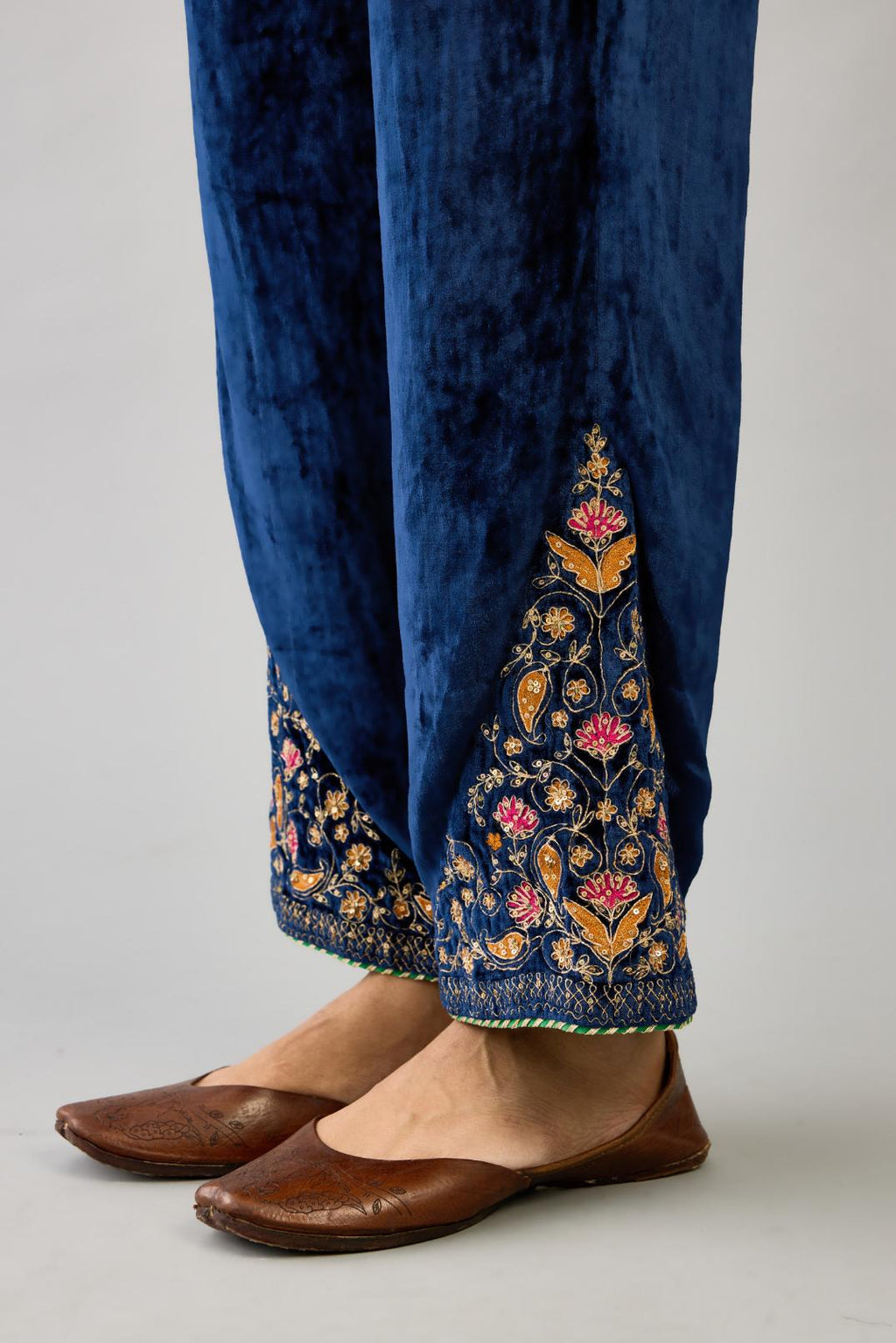 Blue silk velvet straight pants with dori and contrast silk thread embroidery, detailed with gold sequins work.
