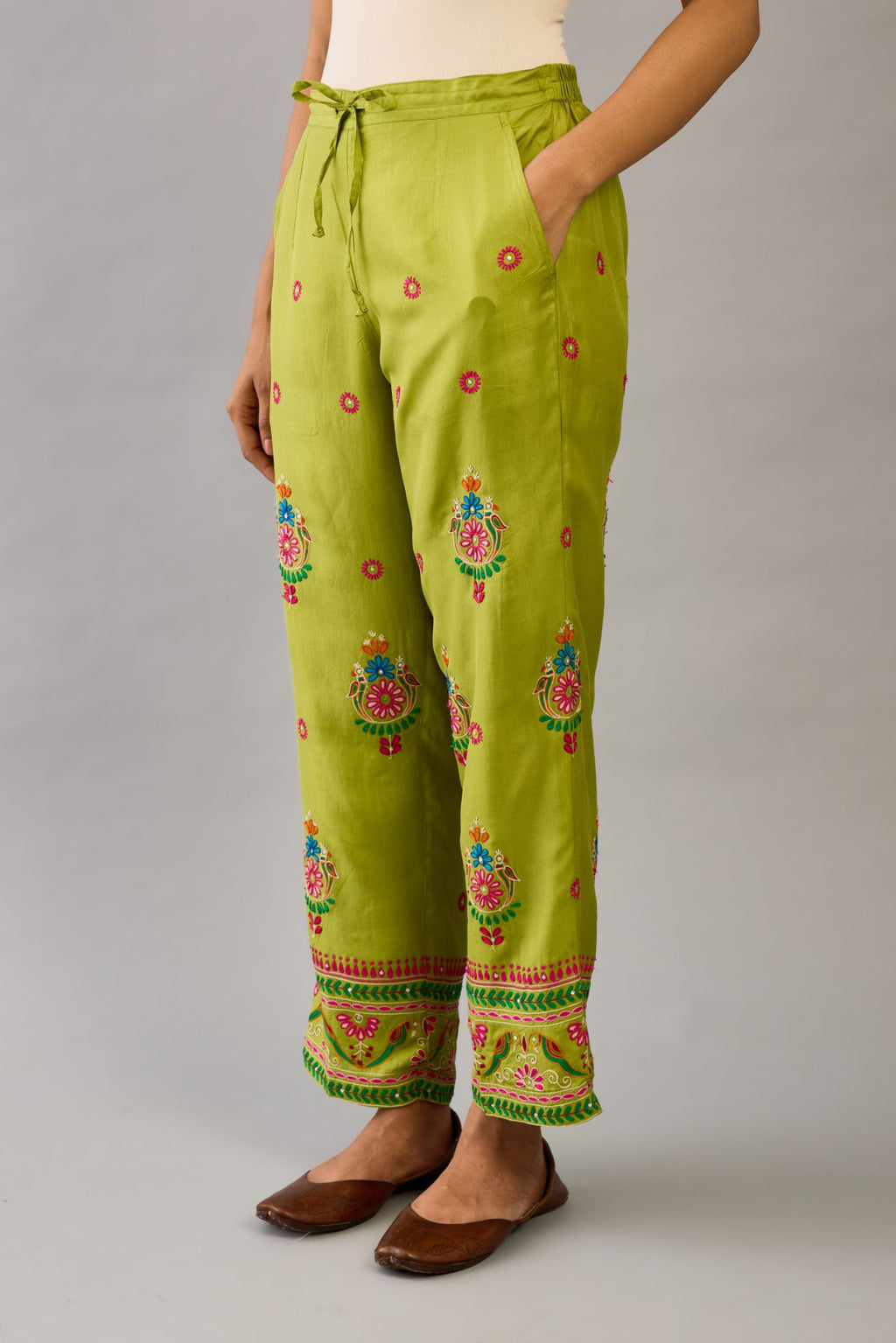 Apple green silk straight pants with all over multi color embroidery detailed with sequins.