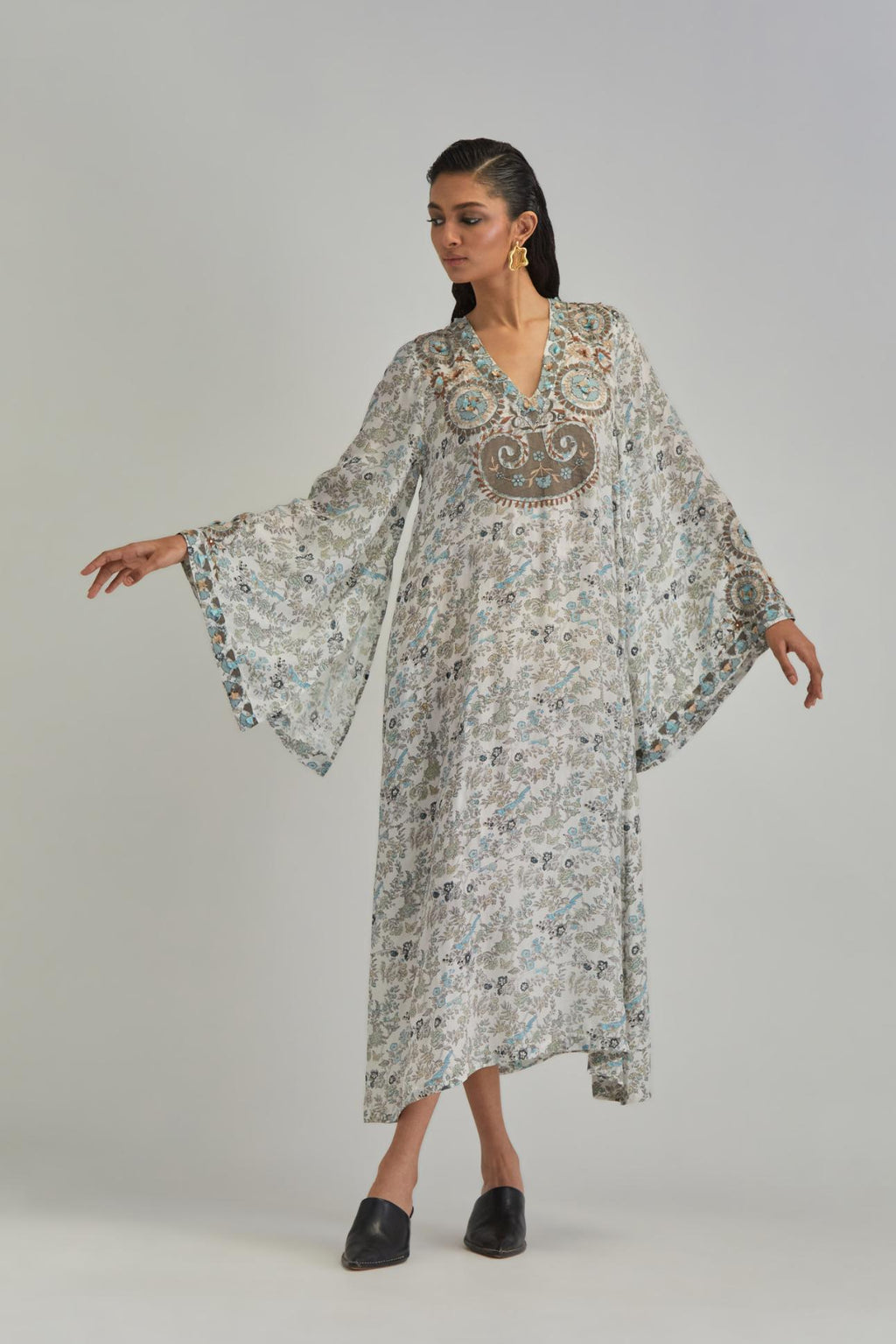 Off White long A-line kaftan with all-over earthy coloured hand block print and appliqué flowers, thread work and silk tassels.