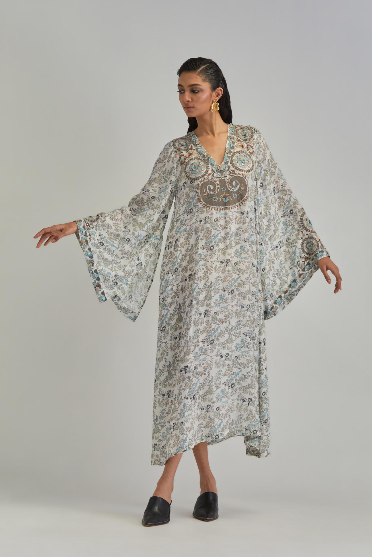 Off White long A-line kaftan with all-over earthy coloured hand block print and appliqué flowers, thread work and silk tassels.