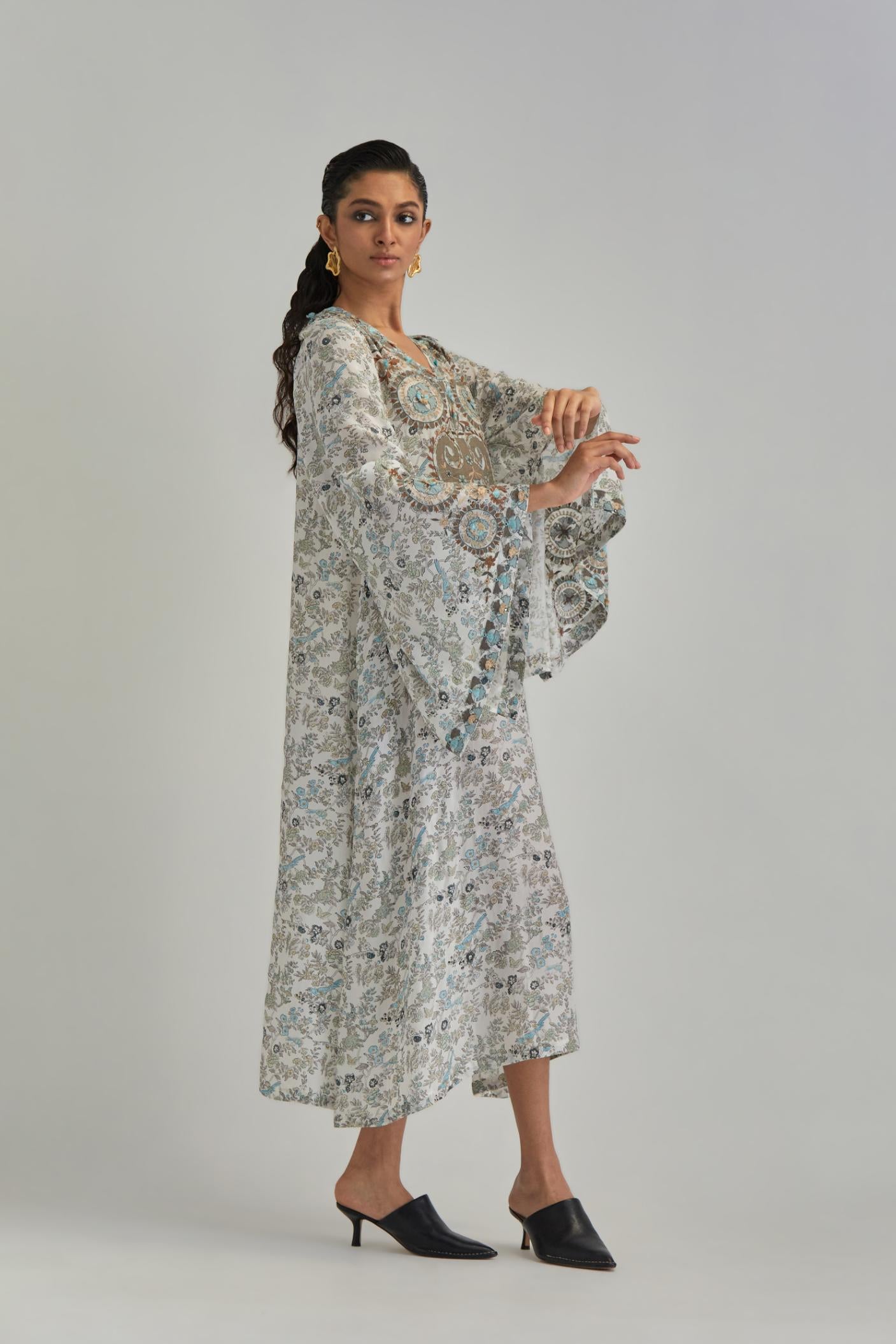 Off White long A-line kaftan with all-over earthy coloured hand block print and appliqué flowers, thread work and silk tassels.