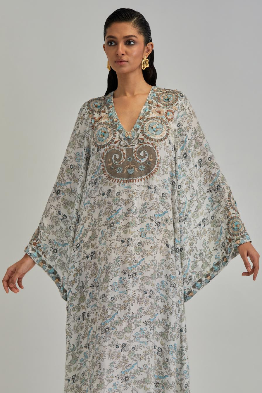 Off White long A-line kaftan with all-over earthy coloured hand block print and appliqué flowers, thread work and silk tassels.