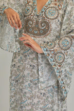 Off White long A-line kaftan with all-over earthy coloured hand block print and appliqué flowers, thread work and silk tassels.
