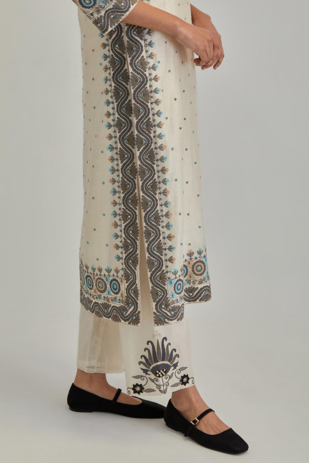 Off White slim fit straight kurta set, decorated with bold appliqué borders all along the side seam, hem and sleeve cuffs.