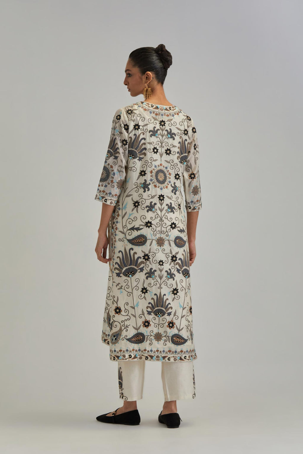 Off White straight kurta set, fully embroidered with bold appliqué flowers, earthy-coloured Aari thread work and silk tassels.
