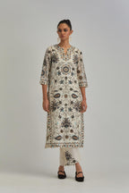 Off White straight kurta set, fully embroidered with bold appliqué flowers, earthy-coloured Aari thread work and silk tassels.