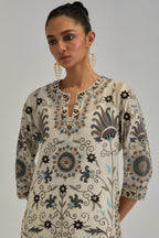 Off White straight kurta set, fully embroidered with bold appliqué flowers, earthy-coloured Aari thread work and silk tassels.