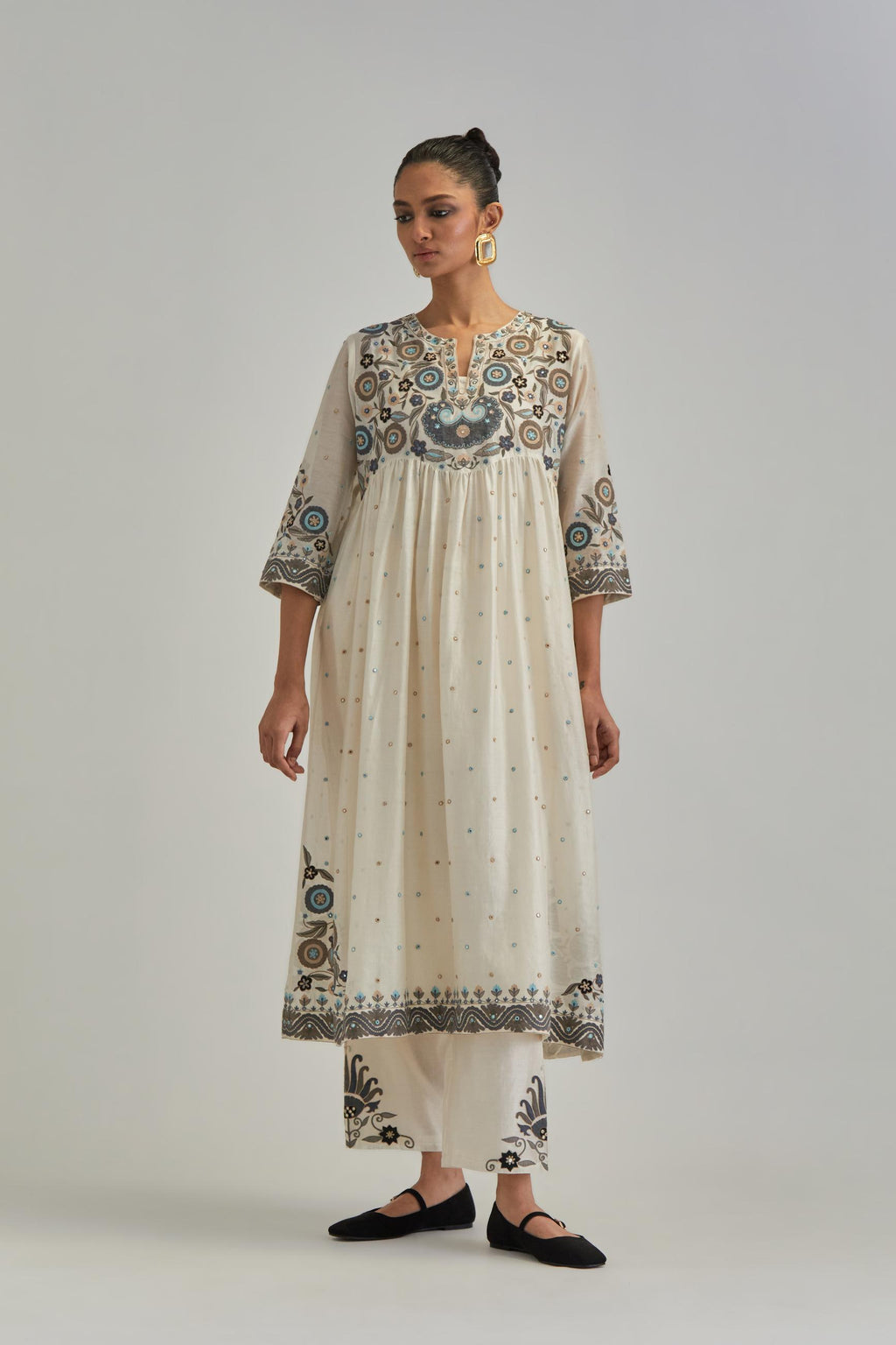 Off White silk Chanderi kurta-dress set with a wavy high-waist and fine gathers. The yoke is fully embroidered with earthy coloured circular appliqué and Aari thread work.