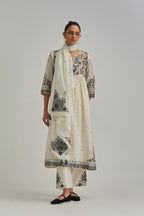 Off White silk Chanderi kurta-dress set with a wavy high-waist and fine gathers. The yoke is fully embroidered with earthy coloured circular appliqué and Aari thread work.