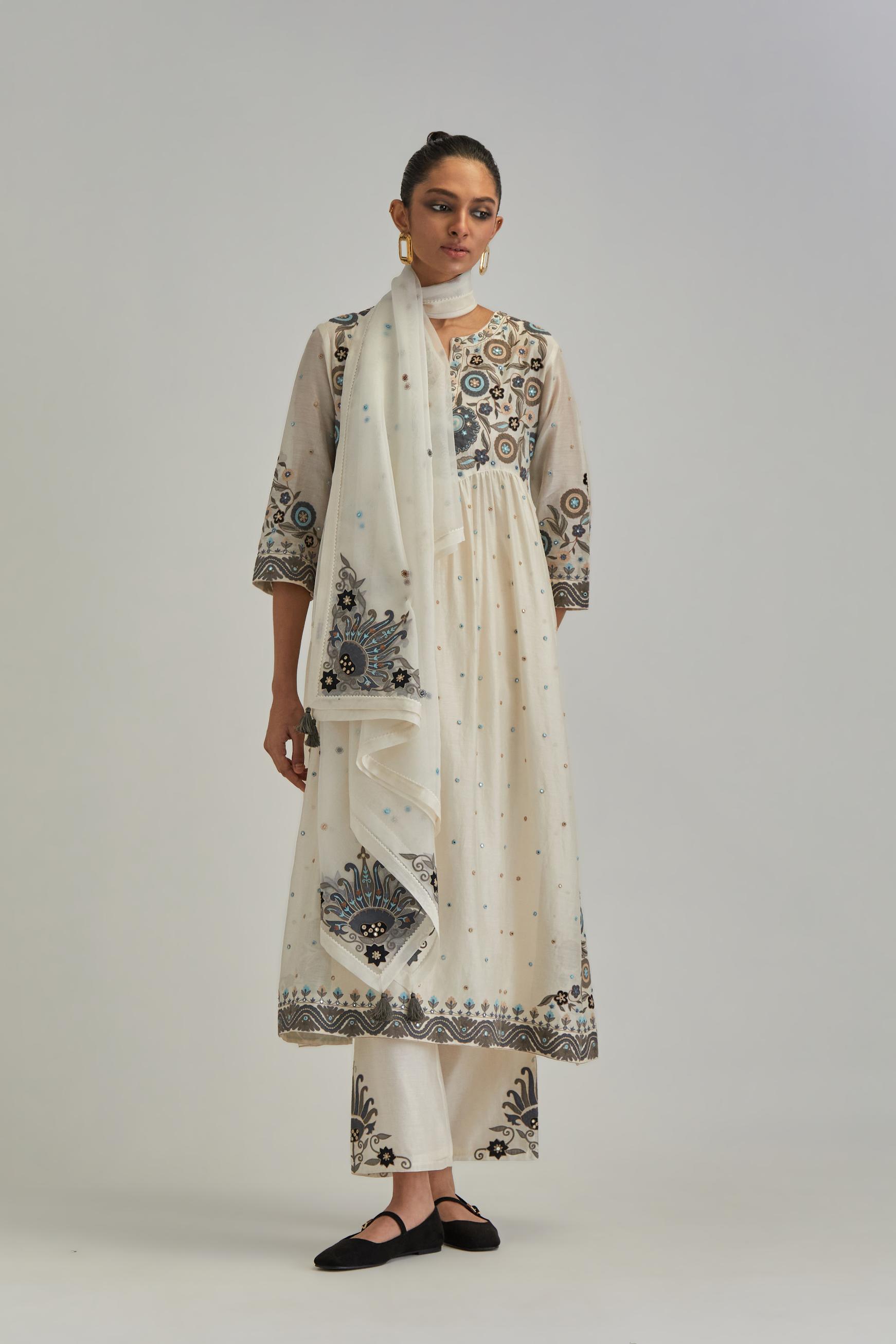 Off White silk Chanderi kurta-dress set with a wavy high-waist and fine gathers. The yoke is fully embroidered with earthy coloured circular appliqué and Aari thread work.