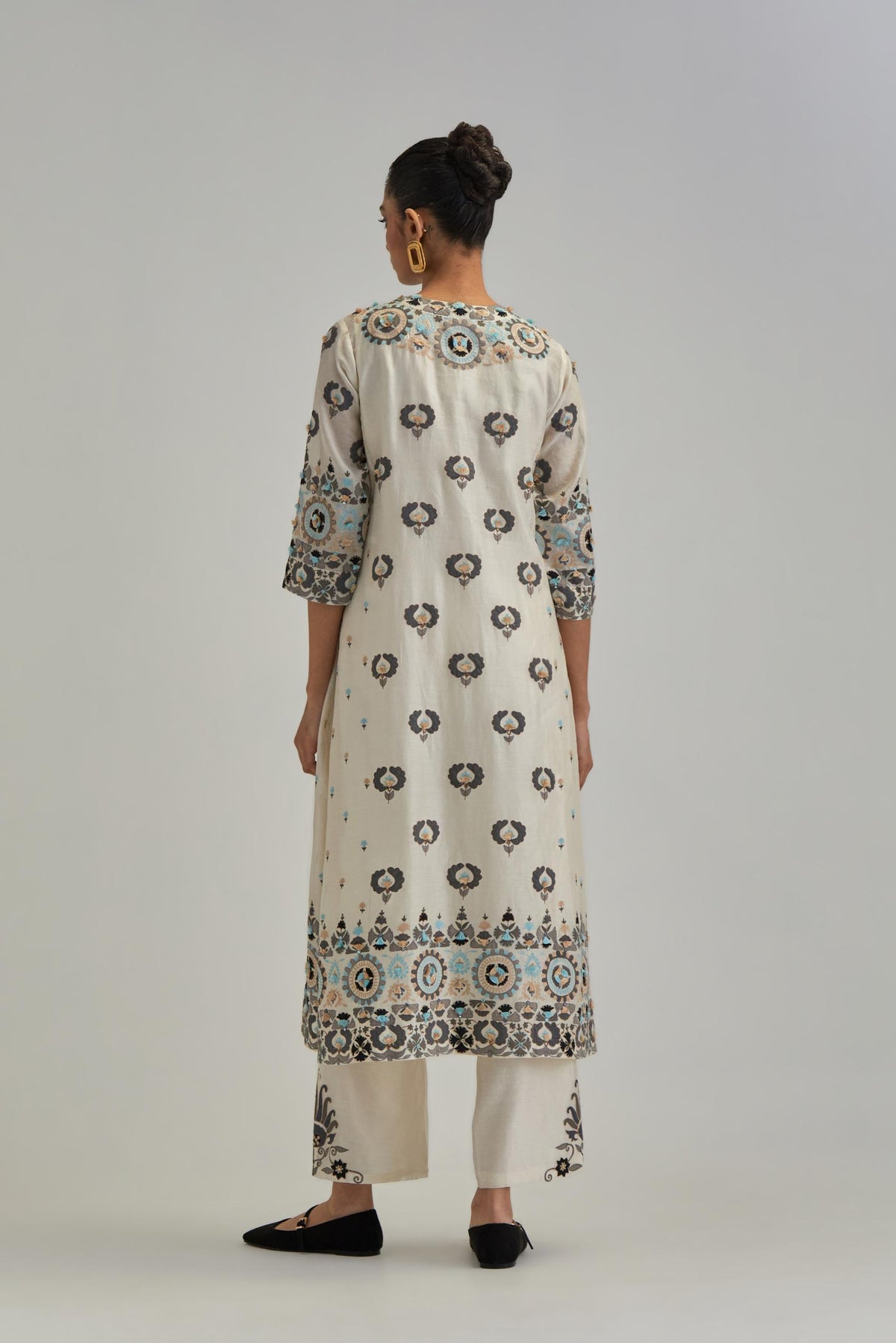 Off White straight kurta, fully embroidered with appliqué flowers, earthy-coloured Aari thread work and silk tassels.