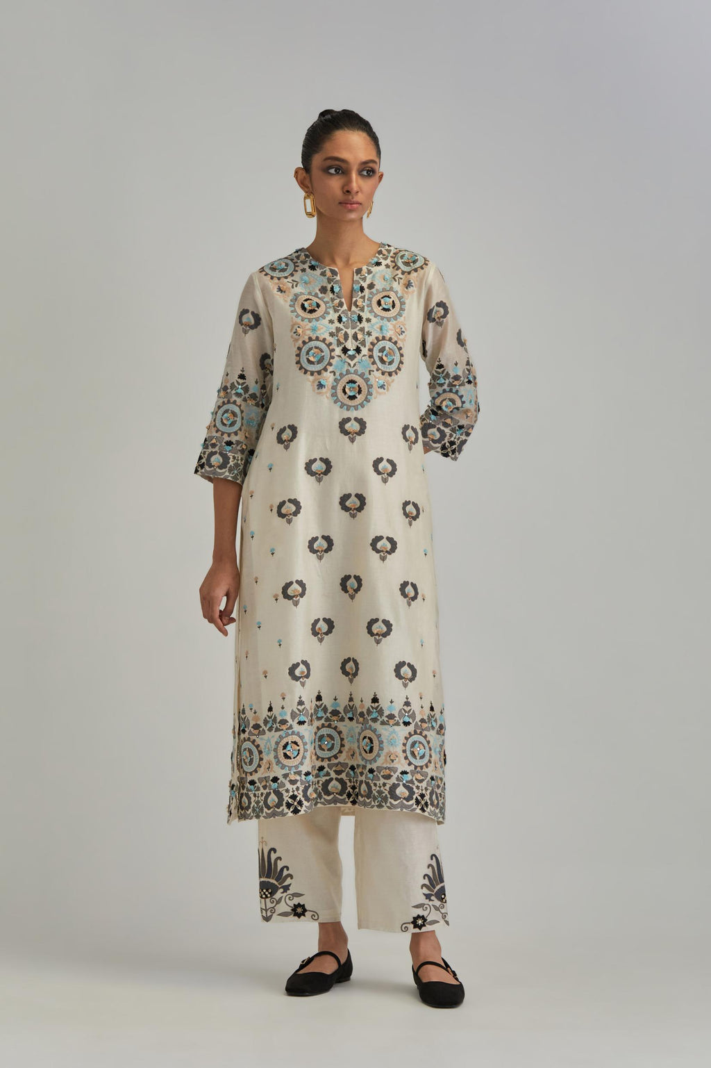Off White straight kurta, fully embroidered with appliqué flowers, earthy-coloured Aari thread work and silk tassels.