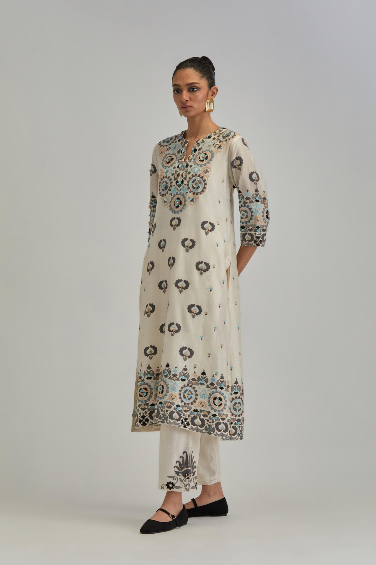 Off White straight kurta, fully embroidered with appliqué flowers, earthy-coloured Aari thread work and silk tassels.