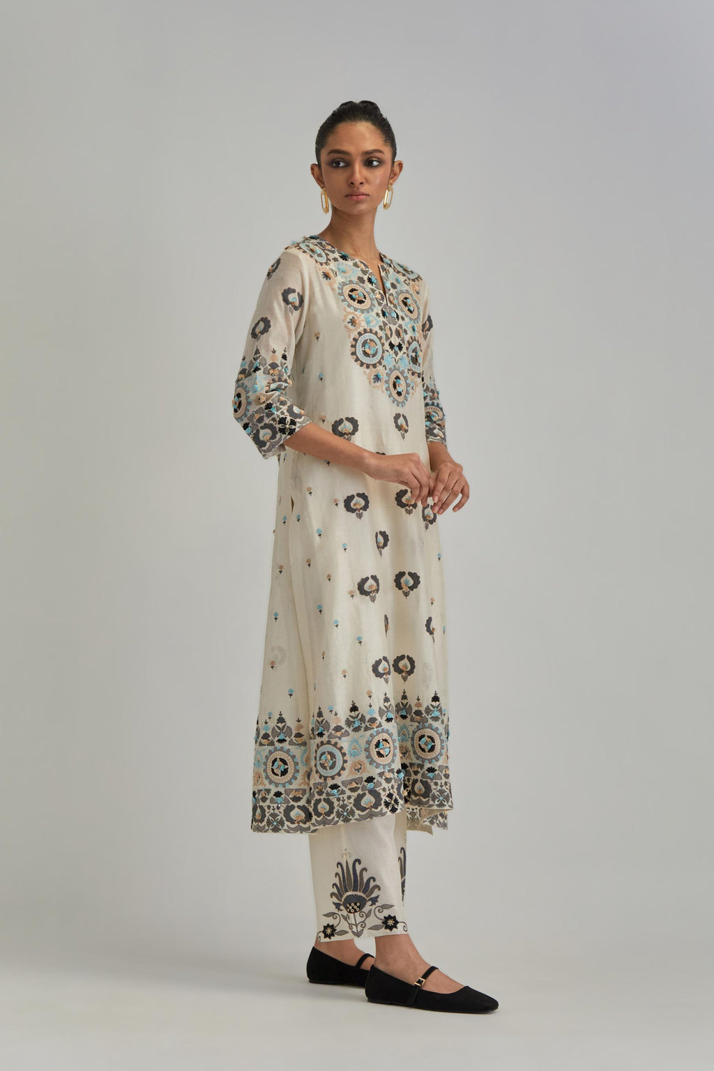 Off White straight kurta, fully embroidered with appliqué flowers, earthy-coloured Aari thread work and silk tassels.