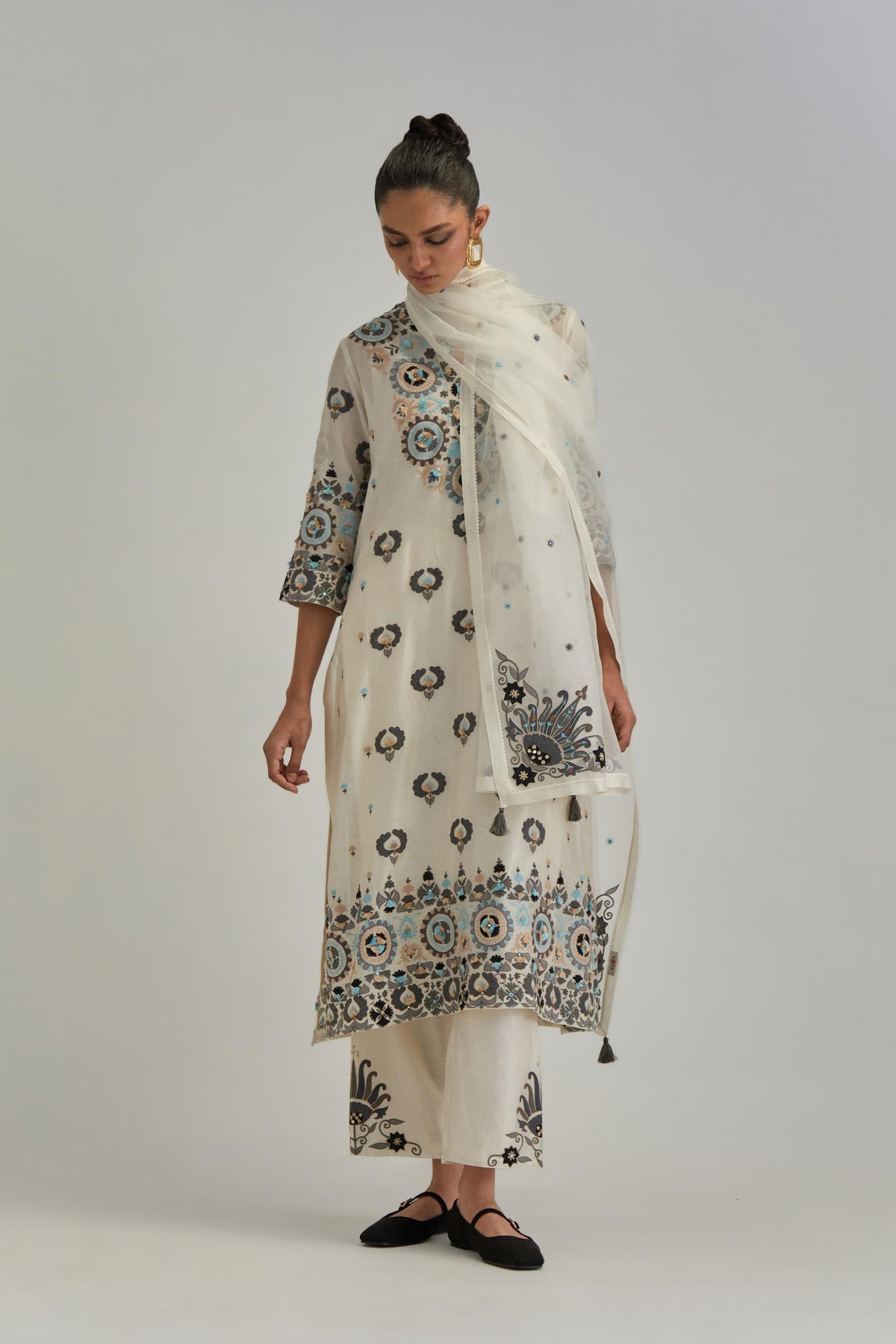 Off White straight kurta, fully embroidered with appliqué flowers, earthy-coloured Aari thread work and silk tassels.