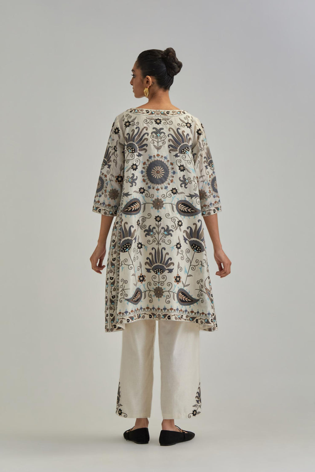 Off White short A-line silk Chanderi kurta set, fully embroidered with earthy coloured appliqué with Aari thread work and silk tassels.