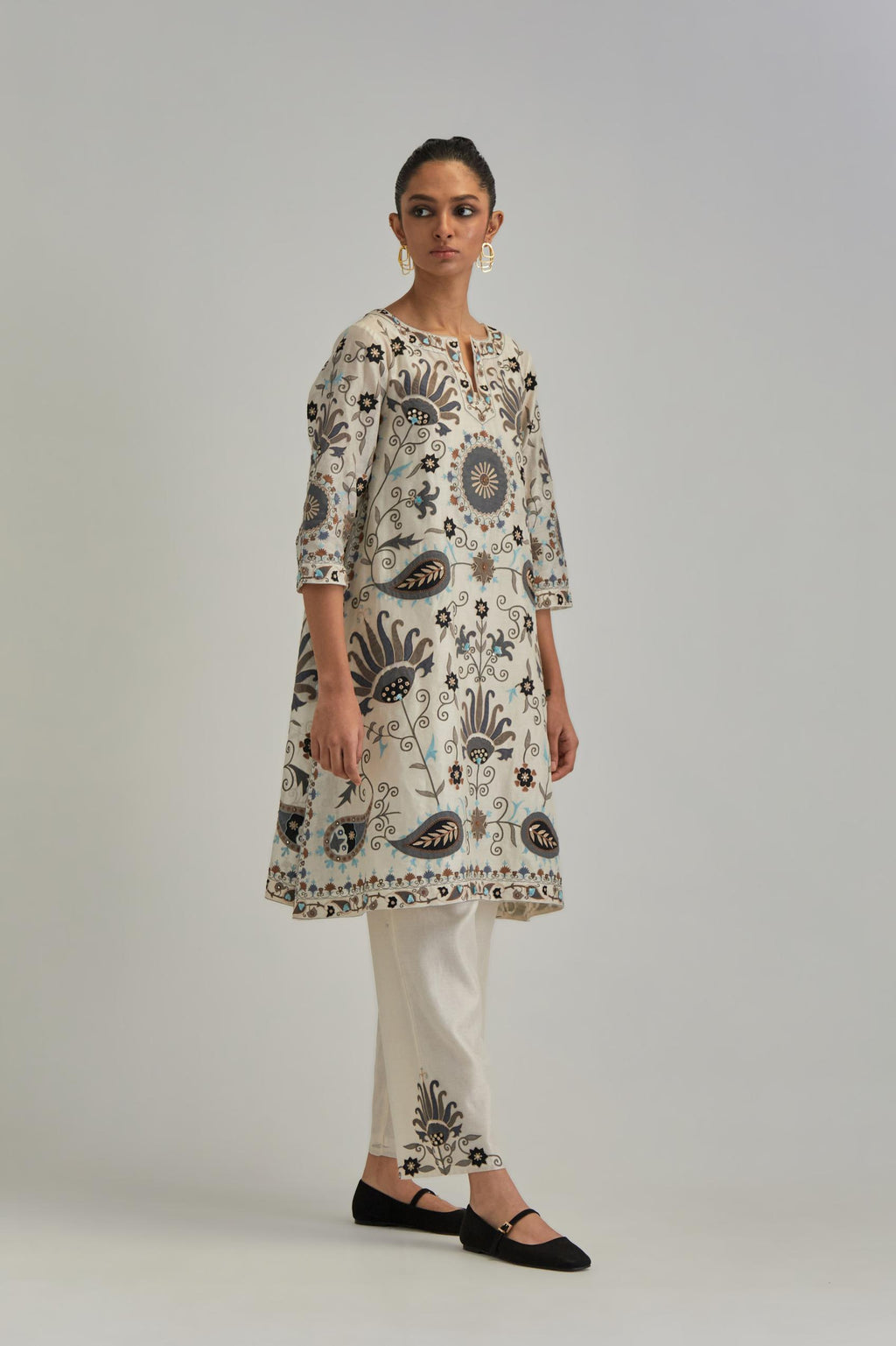 Off White short A-line silk Chanderi kurta set, fully embroidered with earthy coloured appliqué with Aari thread work and silk tassels.
