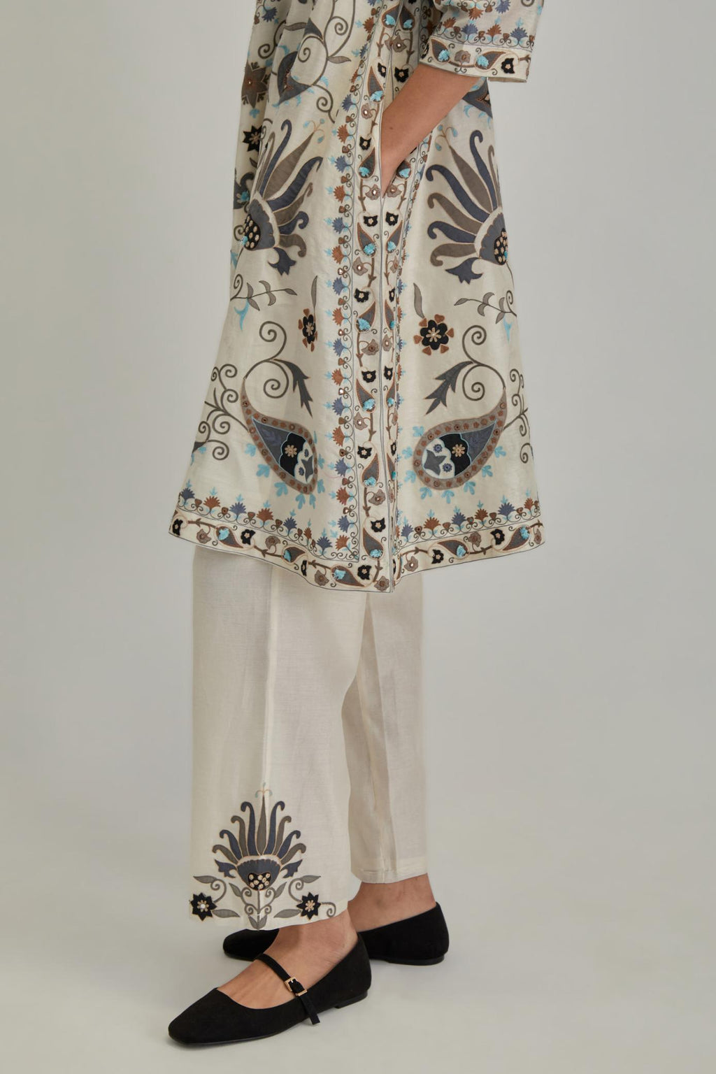 Off White short A-line silk Chanderi kurta set, fully embroidered with earthy coloured appliqué with Aari thread work and silk tassels.