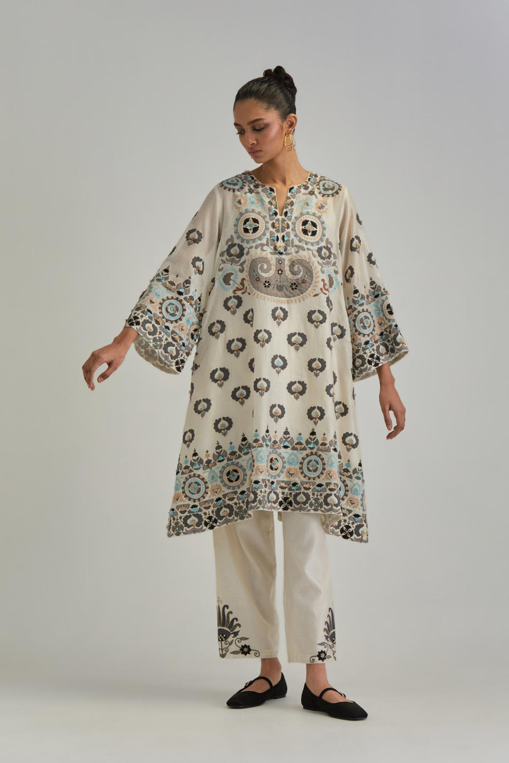 Off White silk Chanderi straight hem mid-length abha style kurta set with bold appliqué embroidery along with earthy-coloured Aari thread work and tassels.