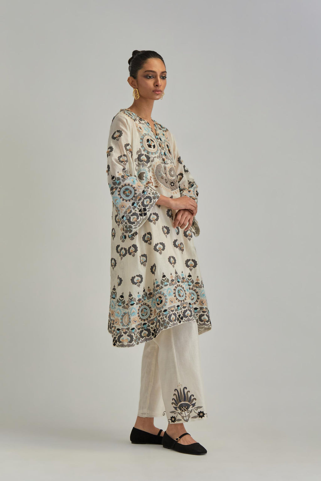 Off White silk Chanderi straight hem mid-length abha style kurta set with bold appliqué embroidery along with earthy-coloured Aari thread work and tassels.