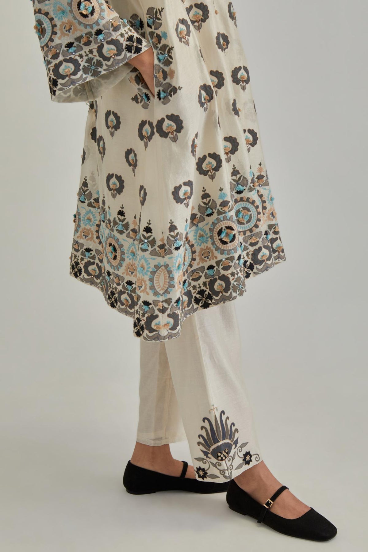 Off White silk Chanderi straight hem mid-length abha style kurta set with bold appliqué embroidery along with earthy-coloured Aari thread work and tassels.