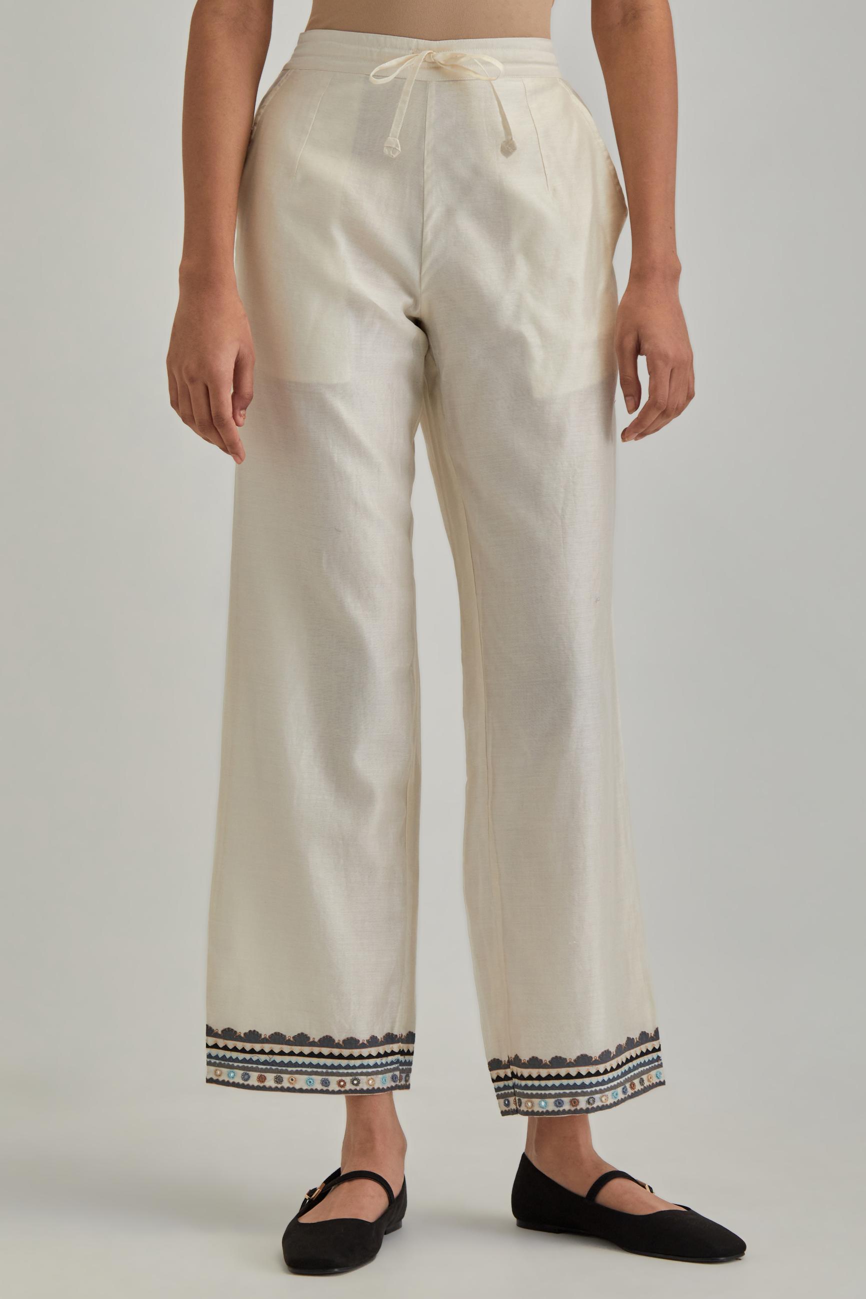 Off white silk Chanderi straight pants with earthy coloured applique and Aari thread work at hem.