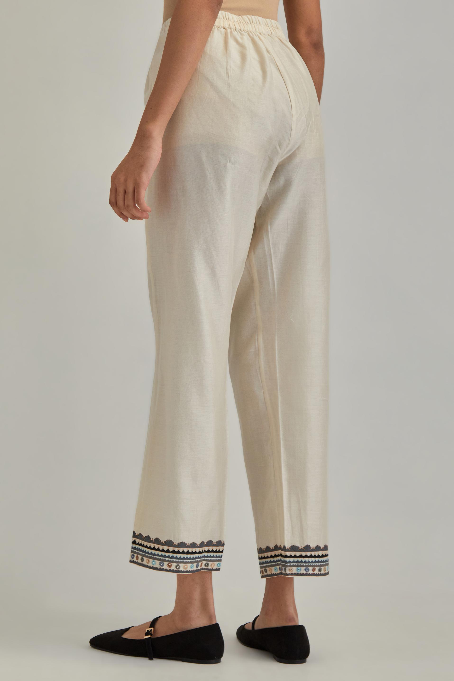 Off white silk Chanderi straight pants with earthy coloured applique and Aari thread work at hem.