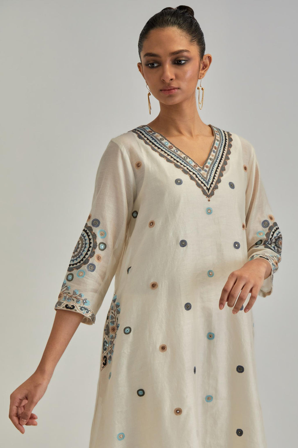 Off White silk Chanderi short V-neck kurta set, with straight hem and side pockets, decorated with fine appliqué and Aari thread embroidery.