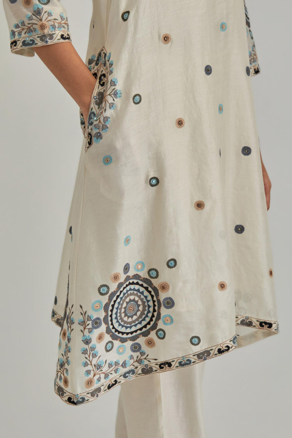 Off White silk Chanderi short V-neck kurta set, with straight hem and side pockets, decorated with fine appliqué and Aari thread embroidery.