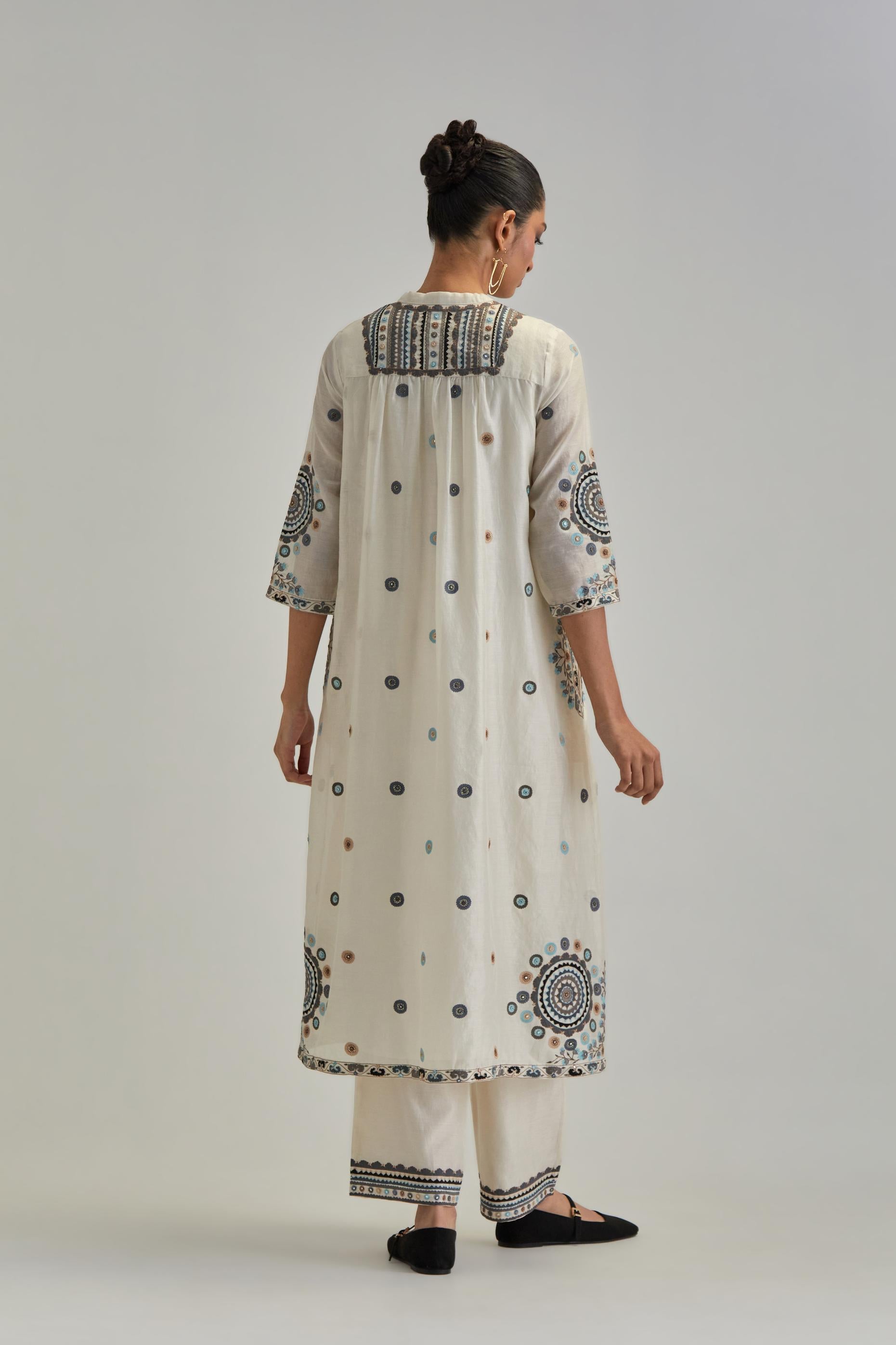 Off White silk Chanderi gathered kurta-dress set with appliqué stripes along with Aari thread work flowers and floral trellises along with a circular appliqued motif.