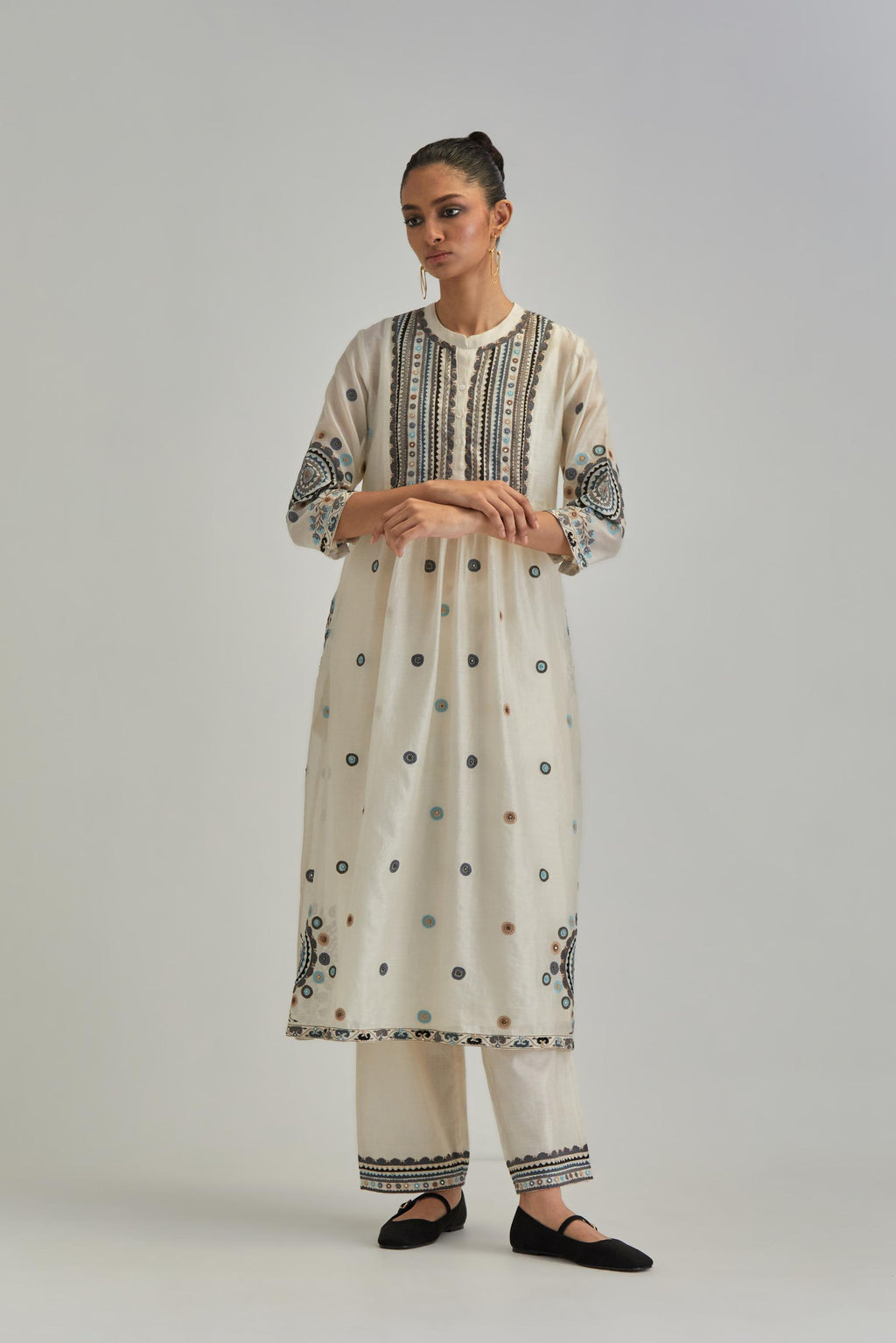 Off White silk Chanderi gathered kurta-dress set with appliqué stripes along with Aari thread work flowers and floral trellises along with a circular appliqued motif.