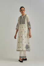 Off White silk Chanderi gathered kurta-dress set with appliqué stripes along with Aari thread work flowers and floral trellises along with a circular appliqued motif.